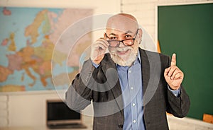 idea and inspiration. become good at geography. senior man teacher at blackboard. bearded tutor in glasses near