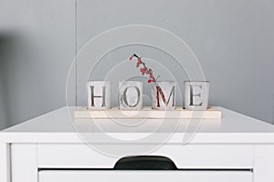 Idea of interior decoration with starfishes, word HOME on glasses standing on the top of bedrrom nightstand