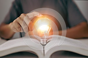 Idea of learning education knowledge online class or e-learning at home. Glowing light bulb and book