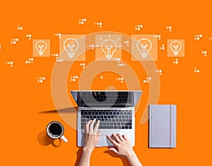 Idea light bulb theme with person using a laptop