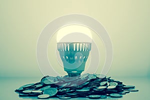 Idea is money concept, Light bulb bright on money coins pile