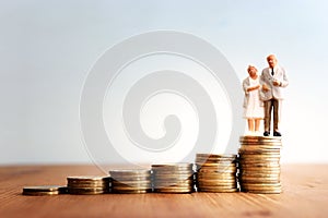 Idea of planning retirement , senior couple standing on stack of coins