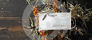 The idea of protecting and treating influenza with folk remedies using healthy sea buckthorn berries.Medical masks with sea