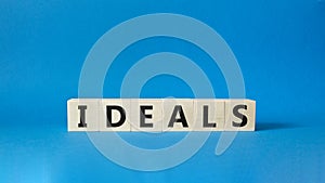 Ideals symbol. Wooden blocks with word Ideals. Beautiful blue background. Business and Ideals concept. Copy space