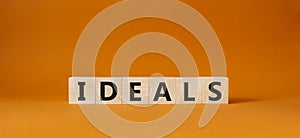 Ideals symbol. Wooden blocks with word Ideals. Beautiful orange background. Business and Ideals concept. Copy space