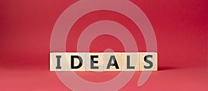 Ideals symbol. Wooden blocks with word Ideals. Beautiful red background. Business and Ideals concept. Copy space