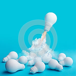 Ideas inspiration concepts with rocket lightbulb flying on group of another lightbulb photo
