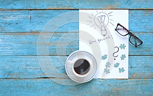 Ideas and problem solution concept with lightbulb scribble, puzzle pieces and a cup of coffee,  creativity, business challenge con
