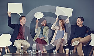 Ideas on what to say in the interview. a group of businesspeople holding up speech bubbles while waiting in line for an