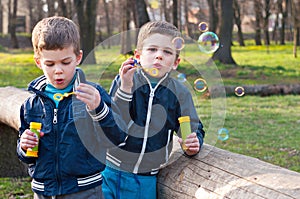 Identical twin brothers blow soap bubbles