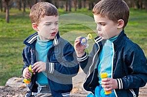 Identical twin brothers blow soap bubbles