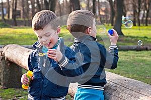 Identical twin brothers blow soap bubbles