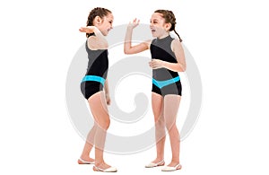 Identical twin girls practice and doing rhythmic gymnastics, white background