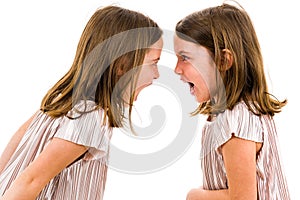 Identical twin girls sisters are arguing yelling at each other