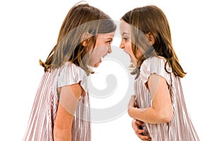 Identical twin girls sisters are arguing yelling at each other