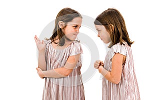 Identical twin girls sisters are arguing yelling at each other