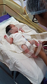 Identification tag being put on the feet of new born infant in hospital