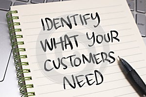 Identify what your customers need  text words typography written on paper against computer keyboard  life and business