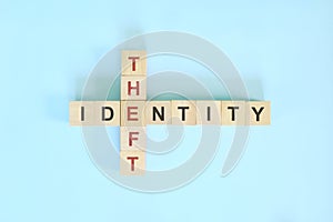 Identity theft concept. Wooden block crossword puzzle flat lay in blue background.