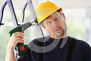 Idiot worker using electric drill portrait photo