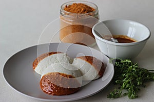 Idli half covered with podi chutney also named as gunpowder. Podi is made of ground pulses, dried red chillies and pepper