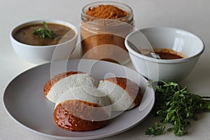Idli half covered with podi chutney also named as gunpowder. Podi is made of ground pulses, dried red chillies and pepper