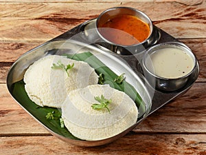 Idli or idly is a healthy Indian, vegetarian, traditional and popular steam cooked rice cakes served with bowls of chutney and
