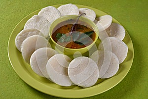 Idli with Sambar in bowl on green background, Indian Dish