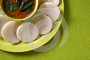 Idli with Sambar in bowl on green background, Indian Dish