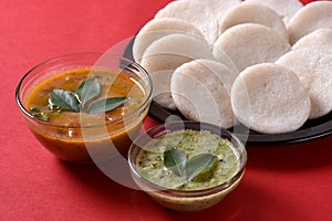 Idli with Sambar in bowl on red background, Indian Dish