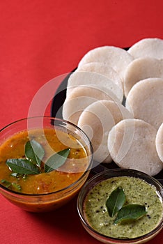 Idli with Sambar in bowl on red background, Indian Dish