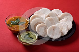 Idli with Sambar in bowl on red background, Indian Dish