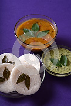 Idli with Sambar and coconut chutney on violet background, Indian Dish