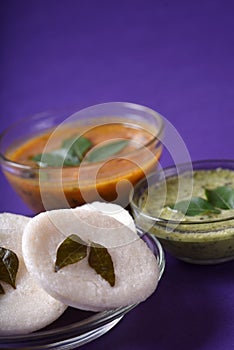 Idli with Sambar and coconut chutney on violet background, Indian Dish