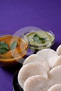 Idli with Sambar and coconut chutney on violet background, Indian Dish