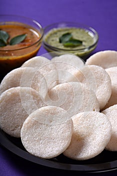 Idli with Sambar and coconut chutney on violet background, Indian Dish