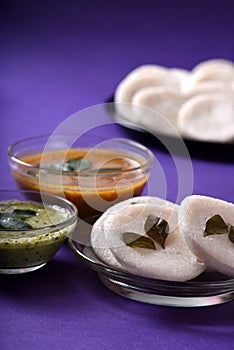 Idli with Sambar and coconut chutney on violet background, Indian Dish