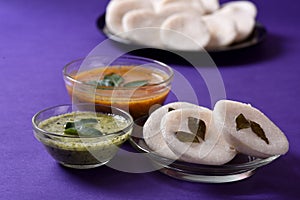 Idli with Sambar and coconut chutney on violet background, Indian Dish