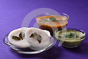 Idli with Sambar and coconut chutney on violet background, Indian Dish