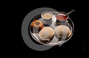 Idli vada with sambhar and chutney a famous south Indian breakfast dish isolated on black background