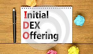 IDO initial DEX offering symbol. Concept words IDO initial DEX offering on beautiful white note. Beautiful wooden table wooden