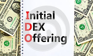 IDO initial DEX offering symbol. Concept words IDO initial DEX offering on beautiful white note. Dollar bills. Beautiful dollar