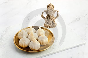 Idol of lord Ganesha with Modak Sweet Dish and flower. Ganesh chaturthi