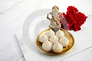 Idol of lord Ganesha with Modak Sweet Dish and flower. Ganesh chaturthi