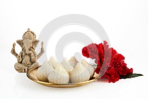 Idol of lord Ganesha with Modak Sweet Dish and flower. Ganesh chaturthi