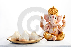 Idol of lord Ganesha with Modak Sweet Dish and flower. Ganesh chaturthi