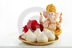 Idol of lord Ganesha with Modak Sweet Dish and flower. Ganesh chaturthi