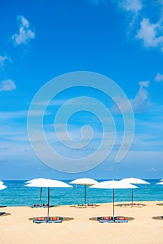 Idollic beach relaxing concept with white parasols on sand