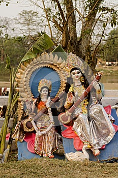 Idols of goddess Saraswati resting under a tree.