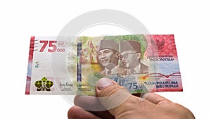IDR Indonesian Rupiah is the official currency of Indonesia. Asian man's hand holding a piece of money to make payment.